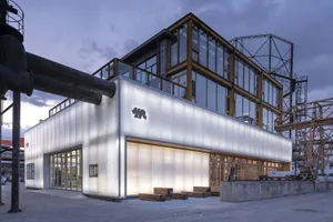Industrial building facade with illuminated glass panels and concrete structure