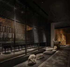 Industrial-style restaurant with metal screens, stone seating, and glass accents.