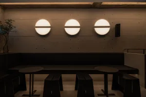 Modern restaurant interior featuring minimalist design with concrete walls and flooring.