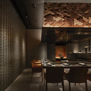 Modern restaurant interior with metallic tiled walls and geometric patterns.