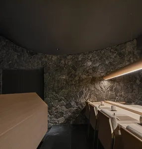 Modern restaurant interior with stone walls and wooden tables and chairs