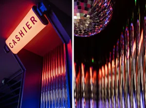 An illuminated 'Cashier' sign mounted on a glass window in a retail setting.