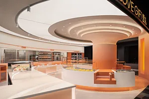 A beautifully modern bakery cafe interior with orange matte walls and white countertop surfaces.