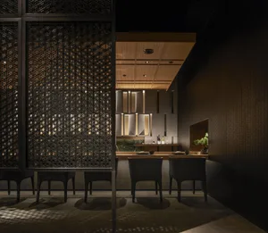 A modern restaurant interior with a black metal frame and metallic patterns on the walls and ceiling.