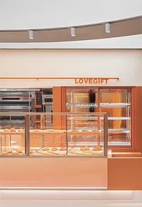 A minimalist bakery interior featuring orange and red acrylic elements.