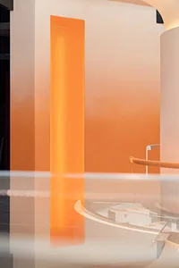 A minimalist interior design featuring orange columns and a reflective floor.
