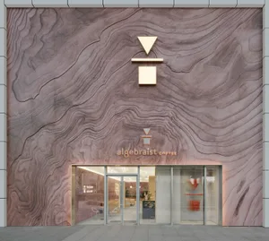 The exterior facade of a modern coffee shop, featuring a unique wooden texture pattern.