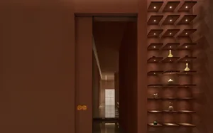 A minimalist bar area featuring metal shelves with illuminated objects.