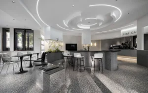 Modern coffee shop interior featuring minimalist design with terrazzo flooring.