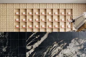 A modern coffee shop with wooden shelves displaying boxes of coffee, and a marble countertop.