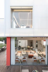 A minimalist residential lounge featuring glass and concrete materials.