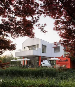 A modern cafe with metal and glass exterior elements surrounded by greenery and trees.