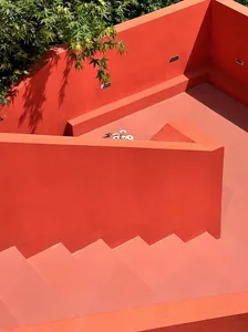 A modern red landscape with concrete stairs and concrete walls.
