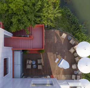 Modern residential patio with wooden flooring and outdoor furniture.