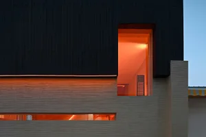 Modern building facade with metallic structure and lighting within the window