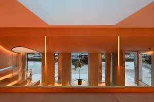 A modern industrial-style office space with concrete walls, floor, ceiling, and lighting.