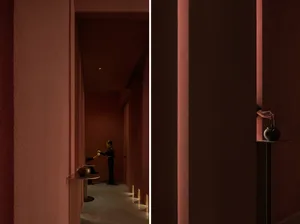 A modern tea room with red walls and a teapot on a table.