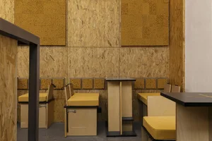 Minimalist interior design featuring wooden structures and cork elements in a restaurant setting.