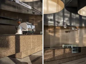 Modern interior of a coffee shop featuring a concrete counter with a coffee machine.