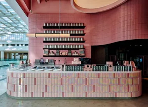 A ceramic-tiled cafe interior with a counter and shelving.