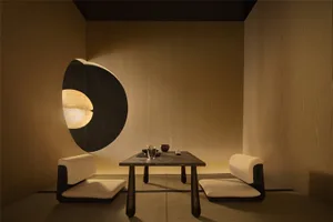 A minimalist restaurant interior featuring a wooden table with tea service, soft lighting, and white seating on tatami mats.