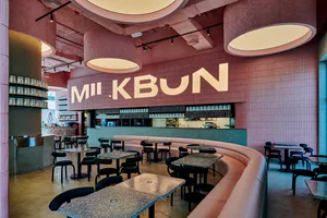 Contemporary minimalist restaurant interior featuring pink concrete walls and pink tiled floors.