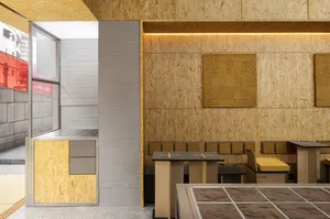Interior shot of a modern restaurant with wooden walls and industrial design elements.