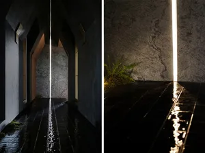 A minimalist interior design featuring polished concrete and a central shaft of light.