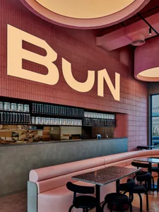 Modern restaurant interior featuring brick walls and clay tiles on the floor.