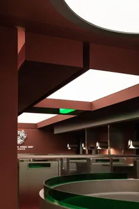 Interior of a modern restaurant featuring metal and glass ceiling panels.