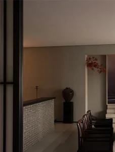 Modern hallway featuring a glass panel wall and minimalist furniture