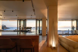 Modern residential kitchen with glass and wood materials.