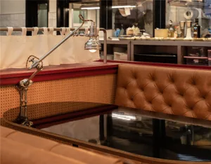 A restaurant booth with a metal lamp and brown leather upholstery