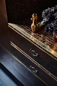 Detailed view of dark wooden furniture with ornate metal handles and decorative elements.