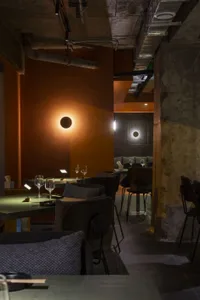 Industrial-style restaurant interior with concrete walls, wooden tables, and metal accents.