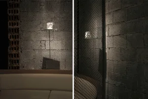 A modern restaurant interior with metal grid walls and concrete elements.