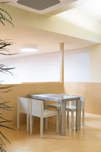 Modern minimalist cafe with white wooden seating and white canvas walls and ceiling.