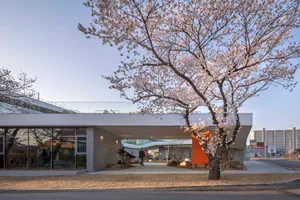 A modern minimalist building with a concrete exterior and glass windows, featuring a contemporary design aesthetic.