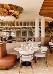 Modern restaurant bar with concrete floor, wood accents, and marble finishes