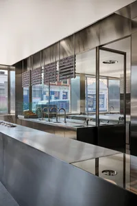 A sleek, modern restaurant counter featuring steel and glass elements
