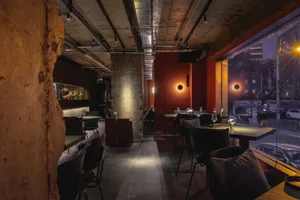 Interior view of a modern restaurant featuring exposed concrete walls and minimalist design.