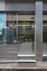 Modern storefront with large glass window and reflections of street.