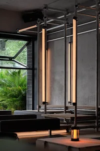 Modern and industrial coffee shop interior with metal columns and fluorescent lighting.