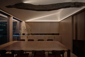 Modern dining room featuring wooden furniture and cabinets.