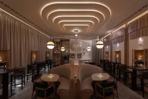Contemporary restaurant bar with modern seating, elegant lighting fixtures, and fabric seating.