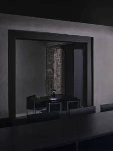 A minimalist black interior with exposed brick wall