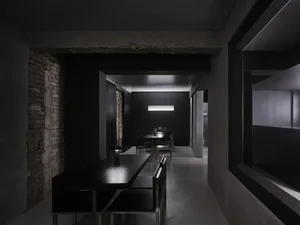 A minimalist restaurant interior featuring concrete and metal elements.