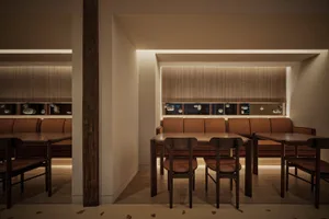 Modern interior design of a restaurant featuring brown leather seating and wooden tables.