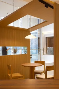 Modern restaurant interior with wooden furniture and glass walls.