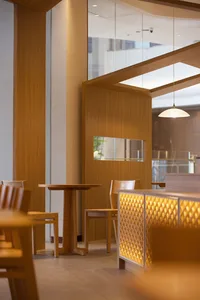 A photograph of a modern restaurant interior featuring wooden furniture and decor.
